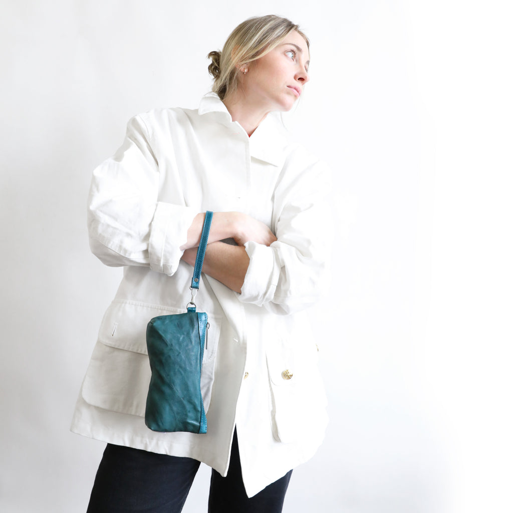 Front view of model with zip pouch medium highlighting wristlet on wrist.  